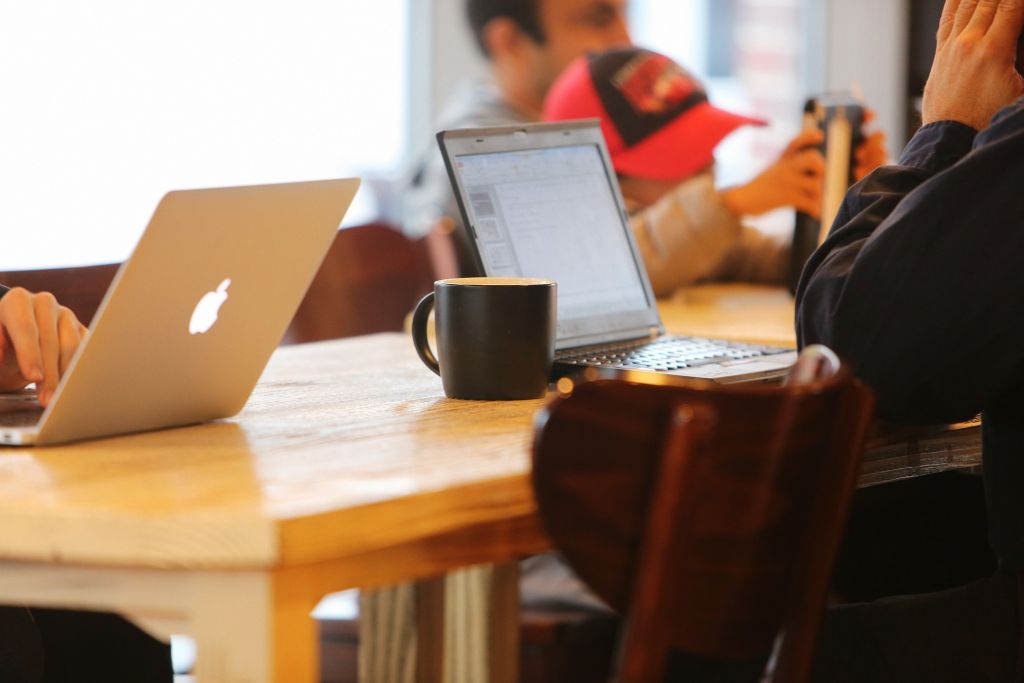 Menschen sitzen mit Notebooks in einem Café