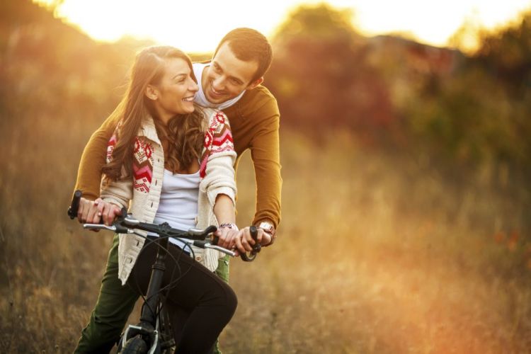 Ein Liebespaar fährt ein Fahrrad im Herbst